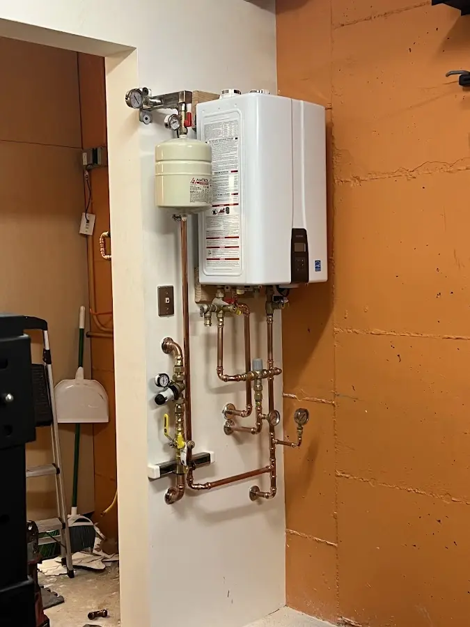Plumbing technician inspecting water heater connections in Elk Ridge